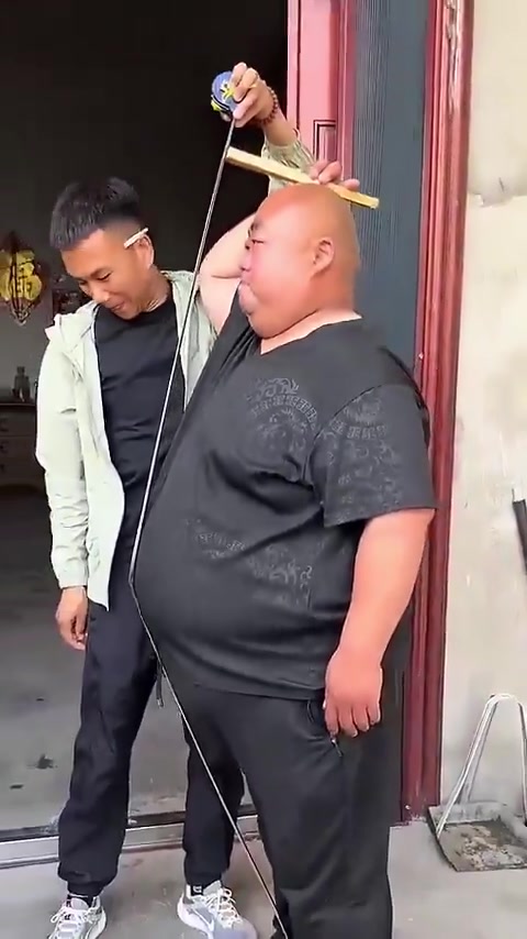 Ils mesurent sa taille avec une règle en bois