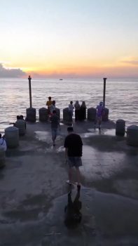 Une vague surprend les promeneurs sur la jetée